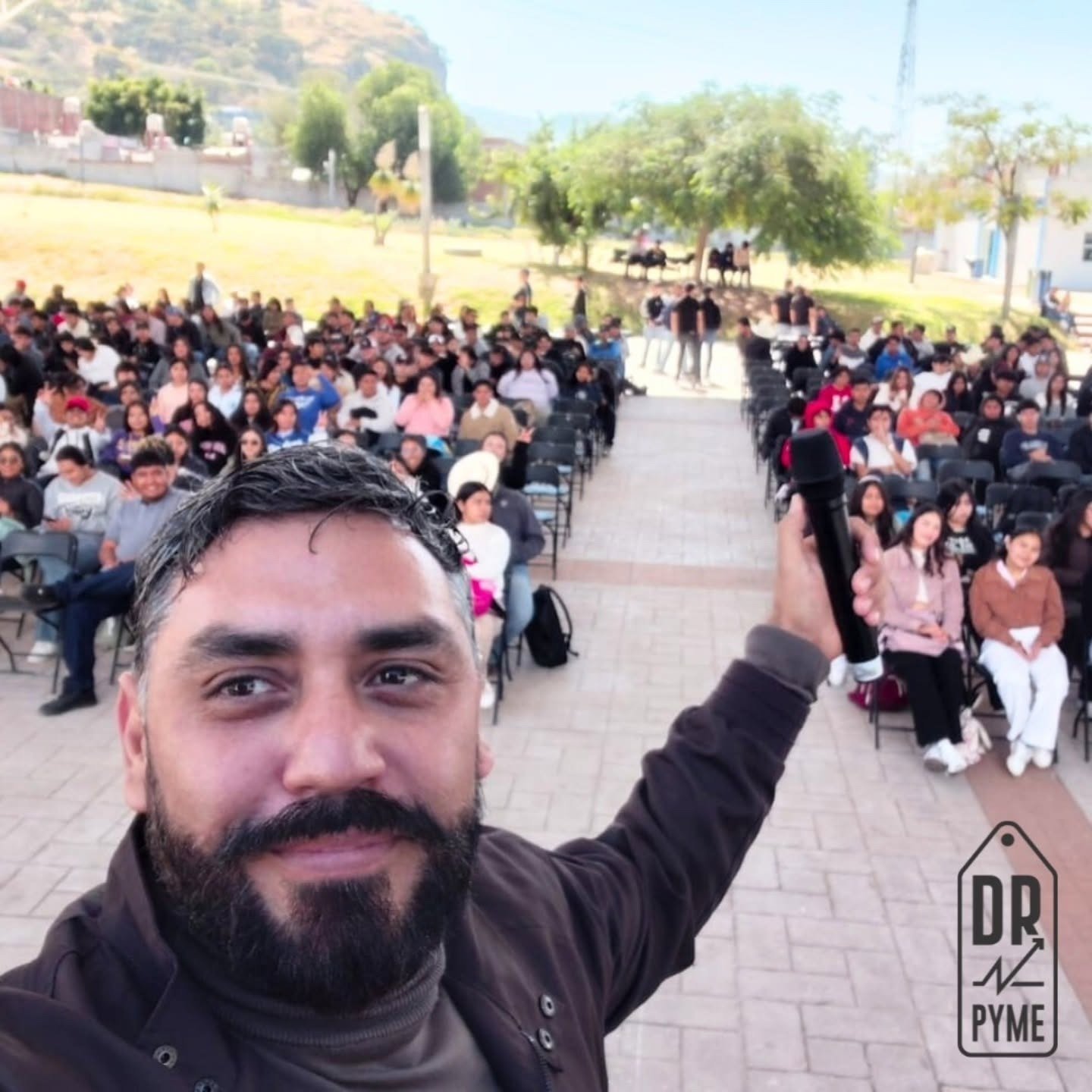 Iván Velázquez frente a cientos de asistentes en conferencia al aire libre.